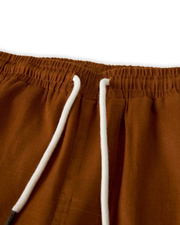 Close-up of The Brisa Linen Pant - Sedona by Dandy Del Mar, showcasing an elastic waistband and white drawstring, perfect for vacation wear.