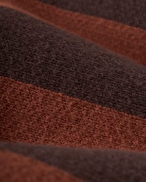 A close-up of the textured Florence Knit Cardigan by Dandy Del Mar, featuring alternating brown and dark brown stripes that highlight the luxurious feel of its jacquard knit.