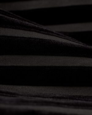 Close-up of The Marsala Kaftan - Onyx by Dandy Del Mar, showcasing dark fabric with alternating stripes of varying textures; some stripes are smooth and shiny, while others have a matte finish, evoking the rich tones of a Marsala kaftan.