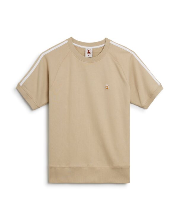 A beige, short-sleeved French Terry Pullover with white stripes on the shoulders, featuring a small embroidered logo on the chest, called The Marseille French Terry Pullover - Ginger by Dandy Del Mar.