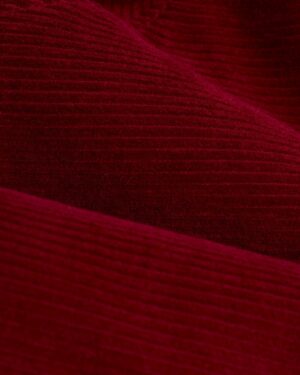 Close-up view of Italian corduroy fabric, showcased in the Dandy Del Mar Corsica Corduroy Jacket - Sangria, highlighting its rich, textured, ribbed surface.