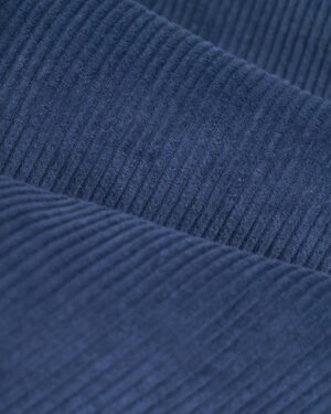 Close-up of folded Moontide 8-wale corduroy fabric from Dandy Del Mar's Corsica Corduroy Shirt, showcasing the ribbed texture and soft material typical of a tailored relaxed fit.