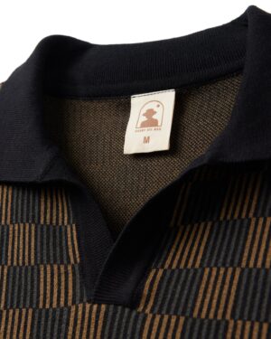 Close-up of a collared shirt with a brown and black checkered pattern. A label inside reads 